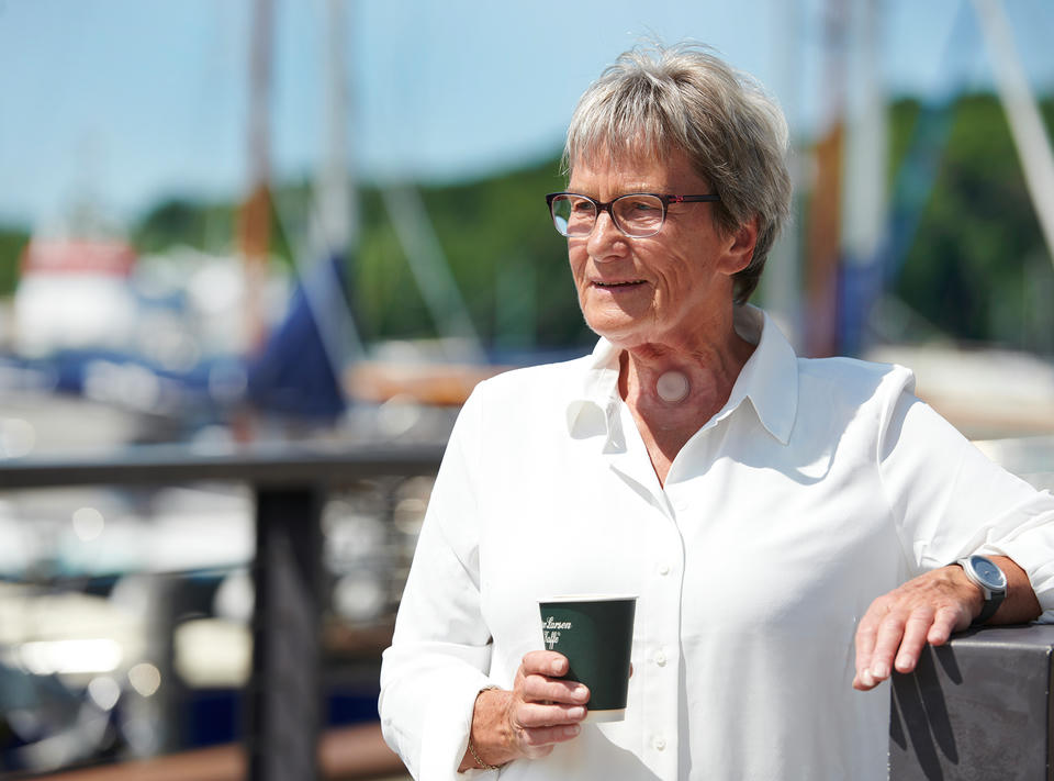 man using provox life hme having coffee outdoors